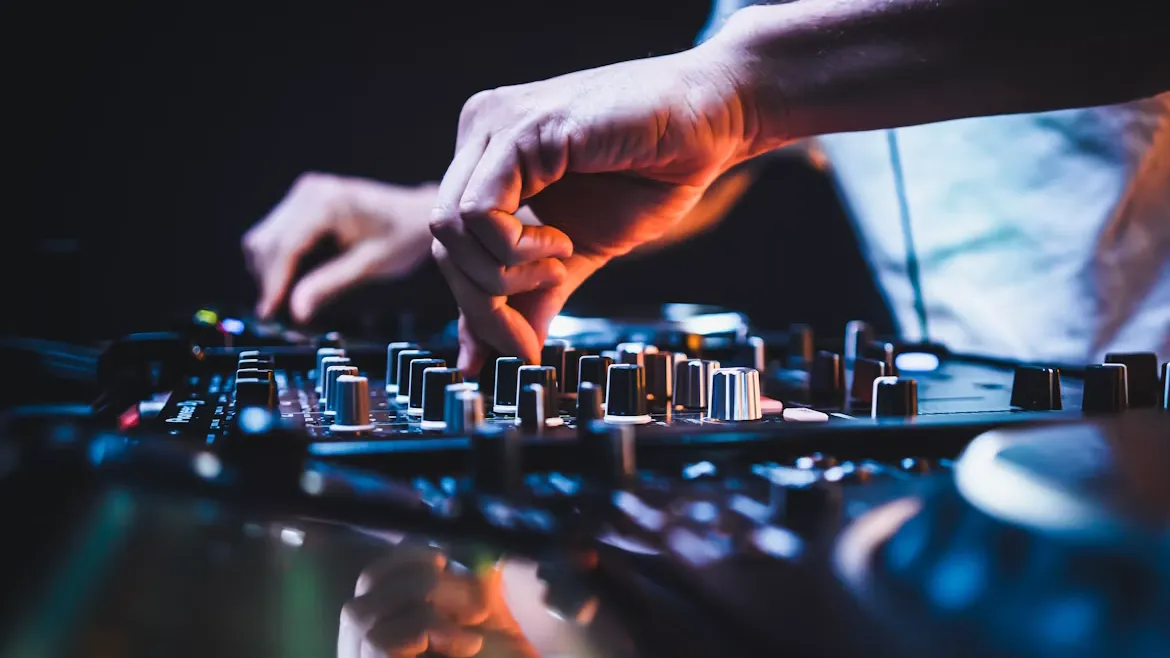 DJ ミキサーのつまみを両手で操作している手元